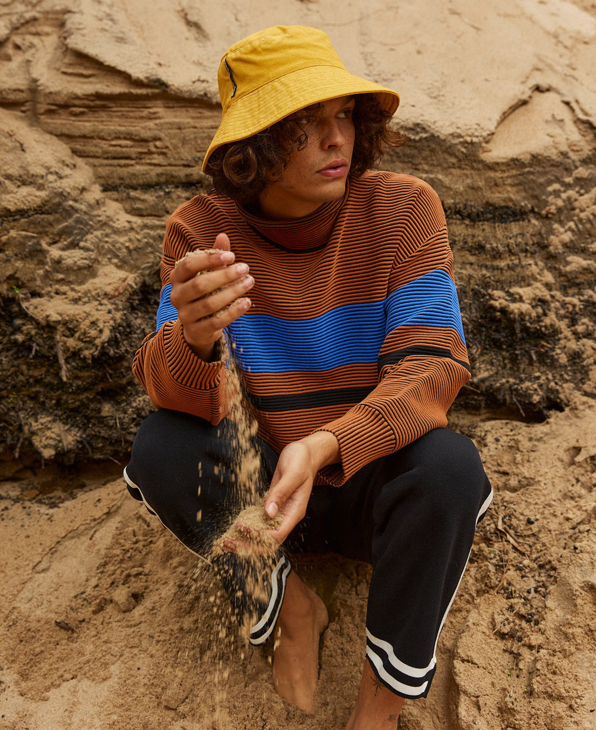 Female model wears the Nagnata Retro Rib Sweater in bronze and azure blue