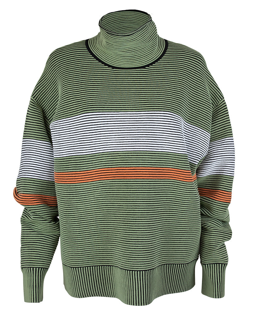 Female model wears the Nagnata Retro Rib Sweater in sage green and cream