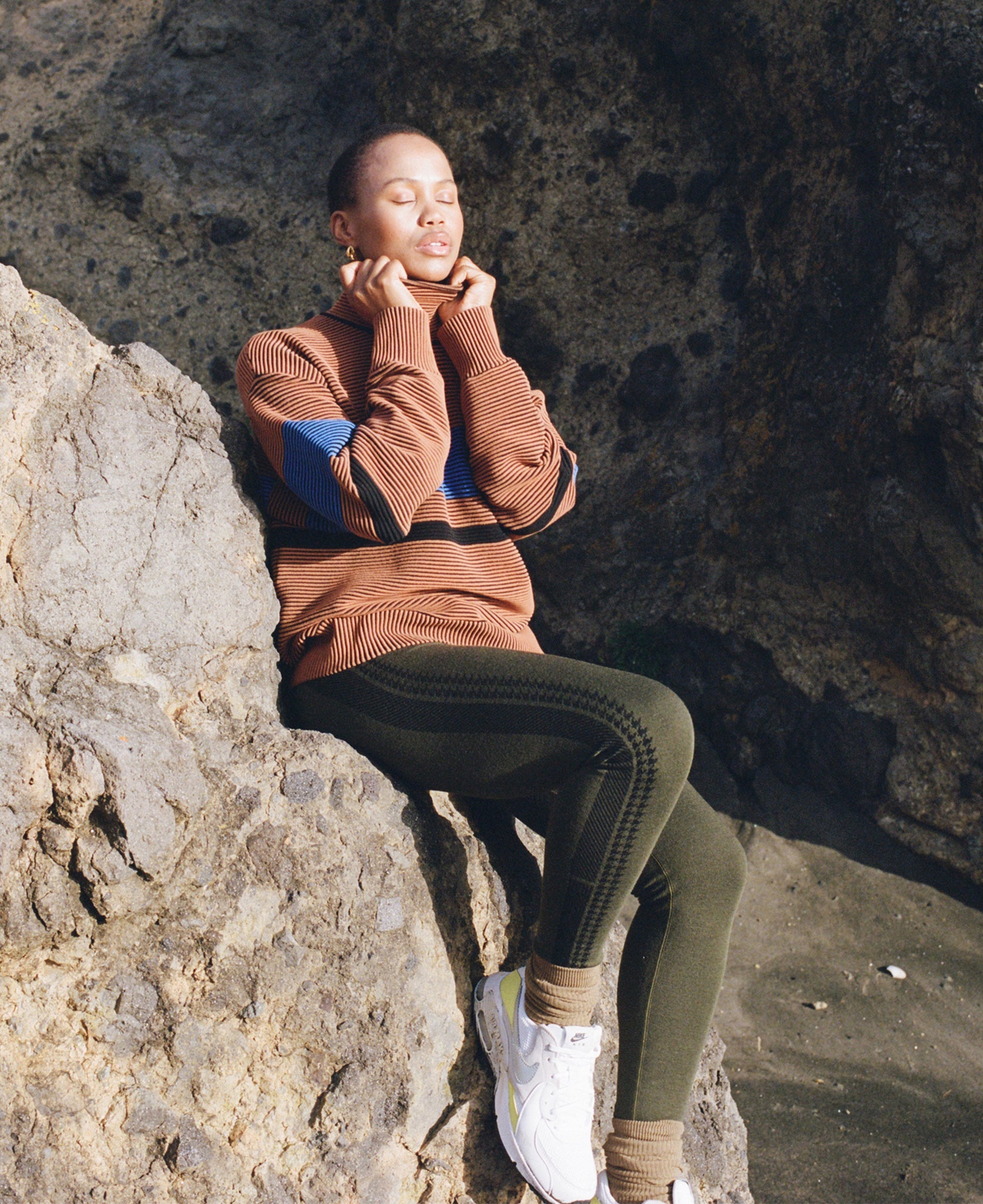 Female model wears the Nagnata Retro Rib Sweater in bronze and azure blue