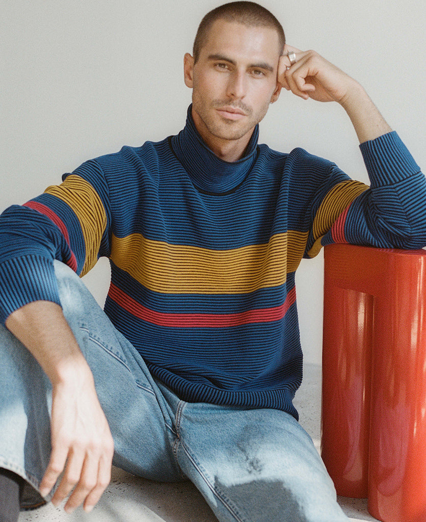 Female model wears the Nagnata Retro Rib Sweater in blue and turmeric