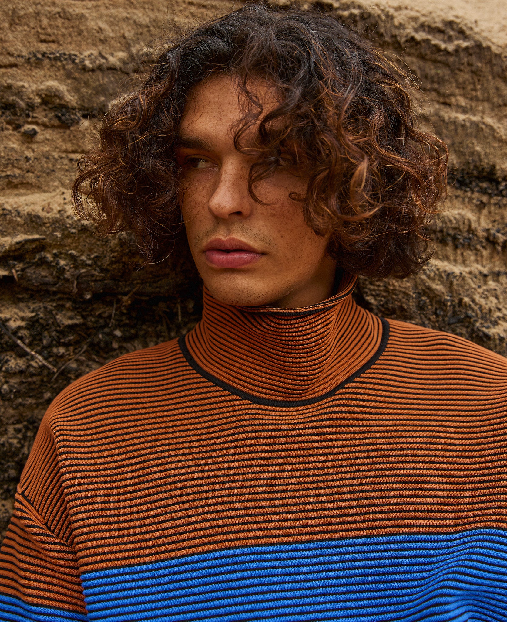 Female model wears the Nagnata Retro Rib Sweater in bronze and azure blue
