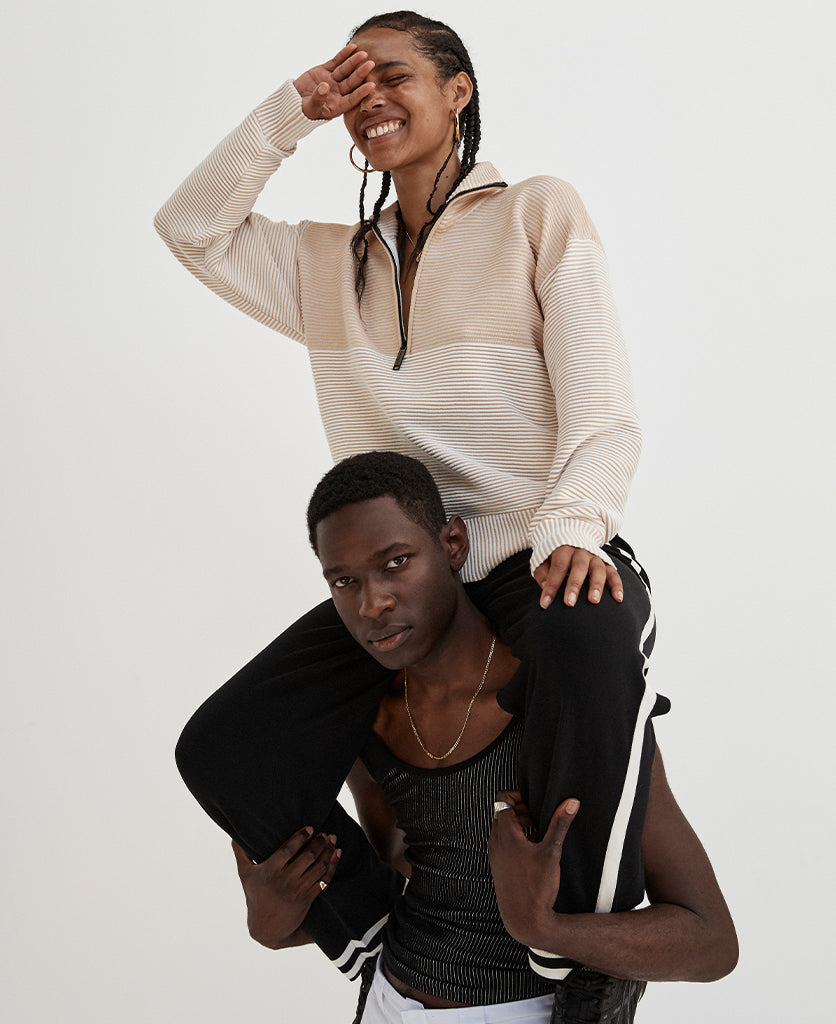 Female model wears the Nagnata Zhen Zip Thru Sweater in sandstone and cream.
