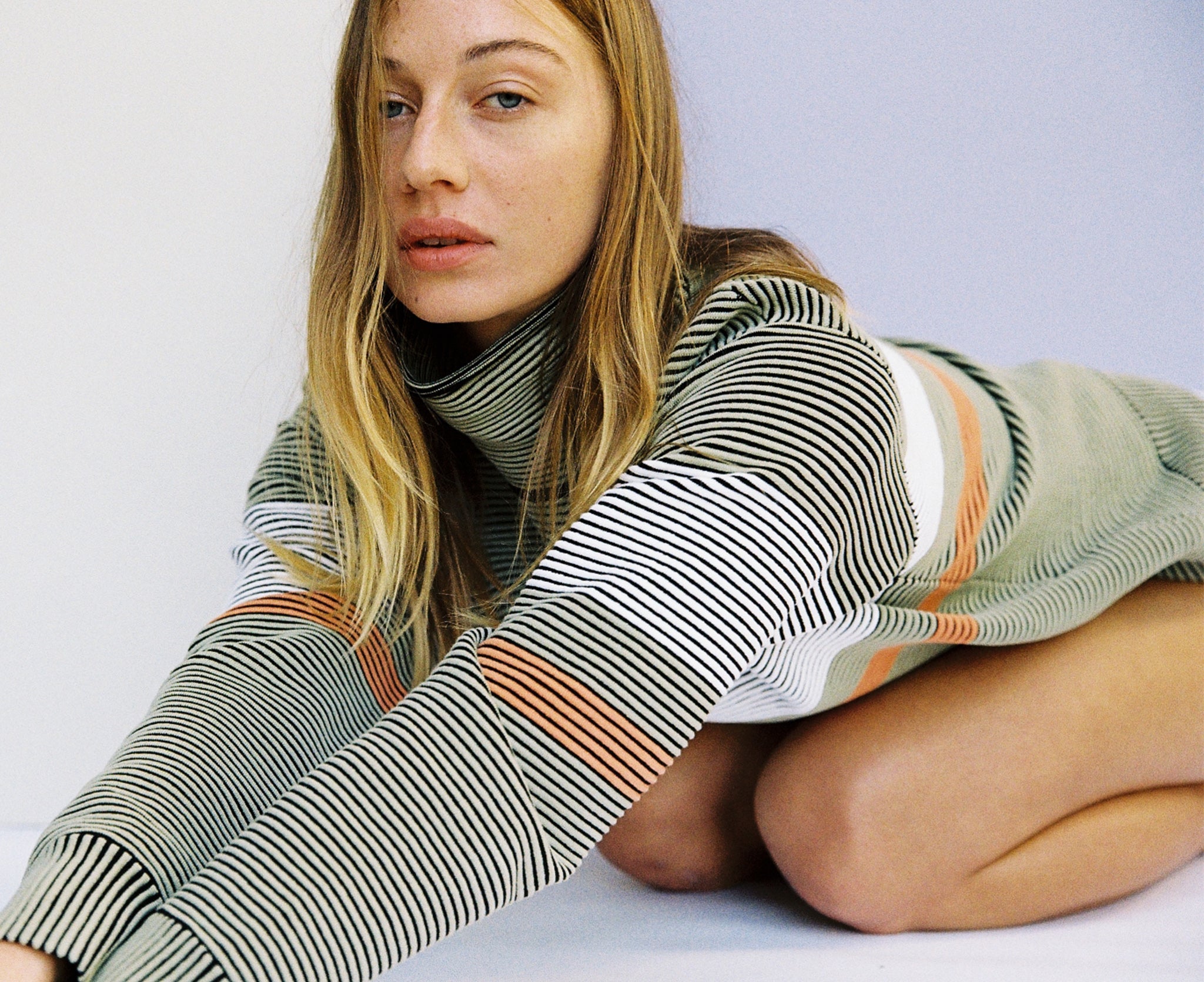 Female model wears the Nagnata Retro Rib Sweater in sage green and cream