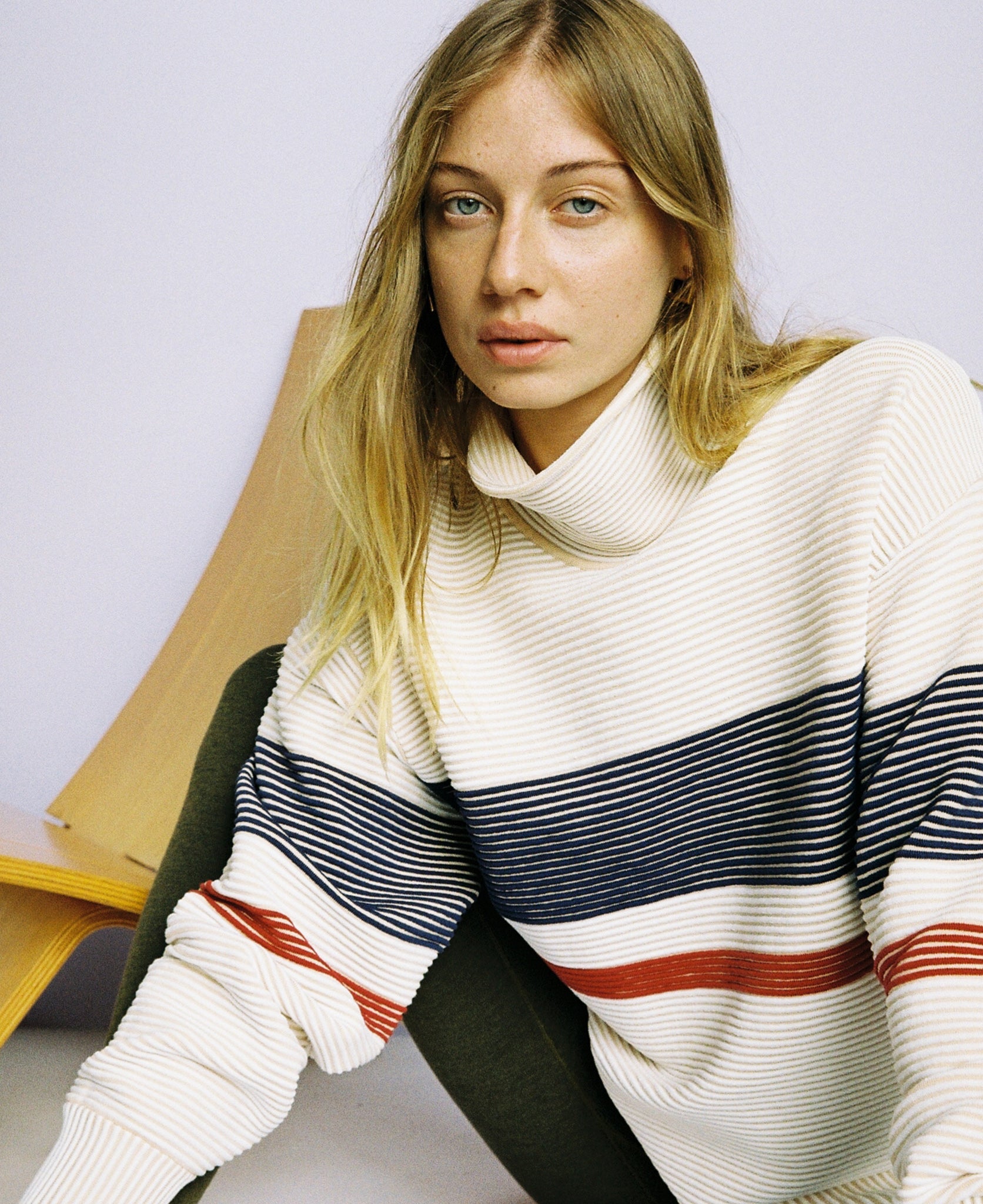 Female model wears the Nagnata Retro Rib Sweater in cream and navy