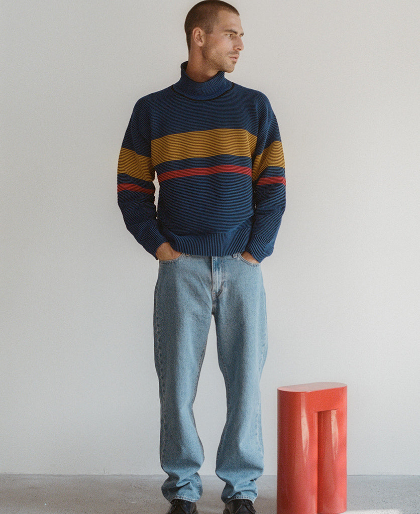 Female model wears the Nagnata Retro Rib Sweater in blue and turmeric