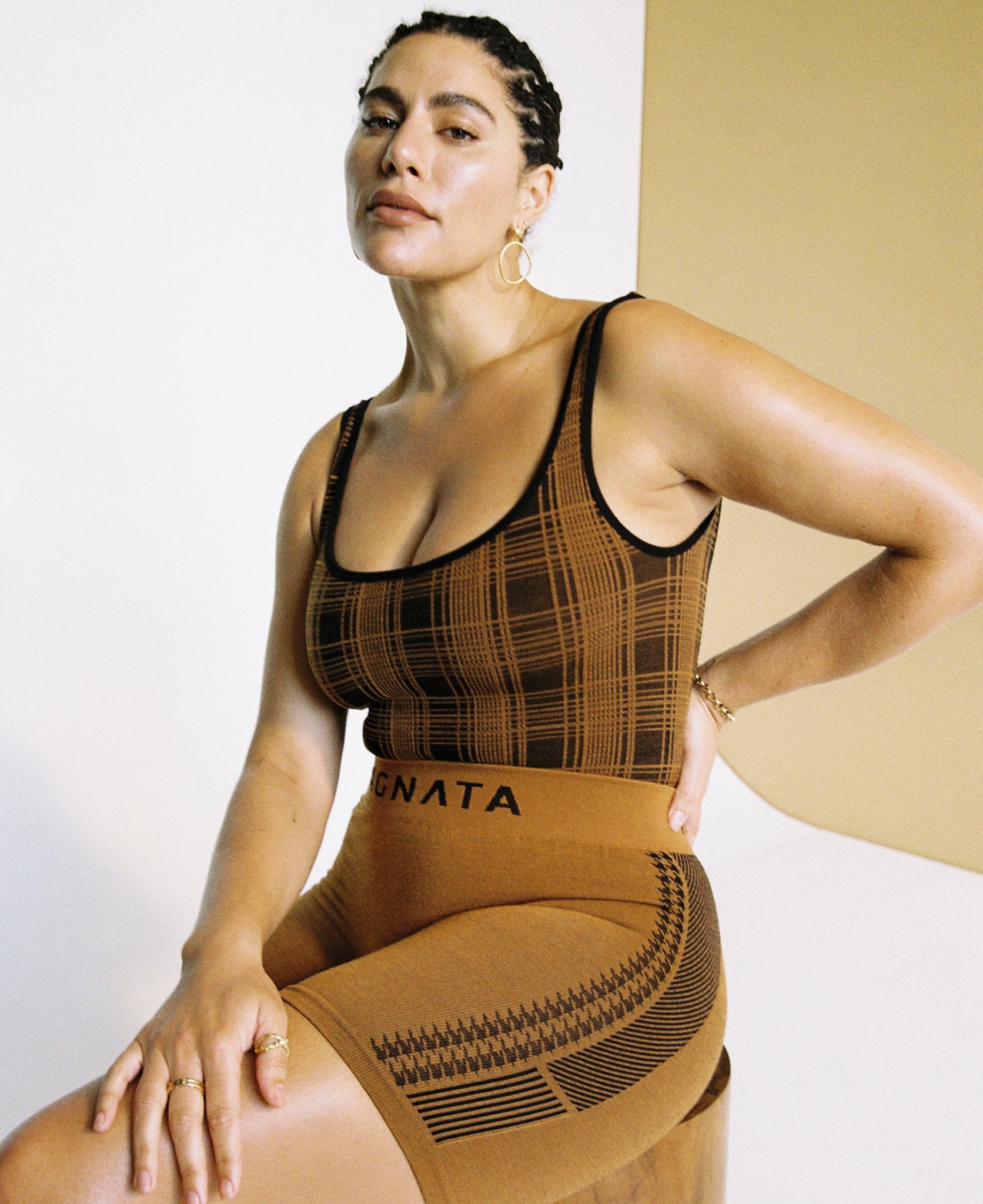 Female model wears the Nagnata Check-Back Bodysuit in black & bronze