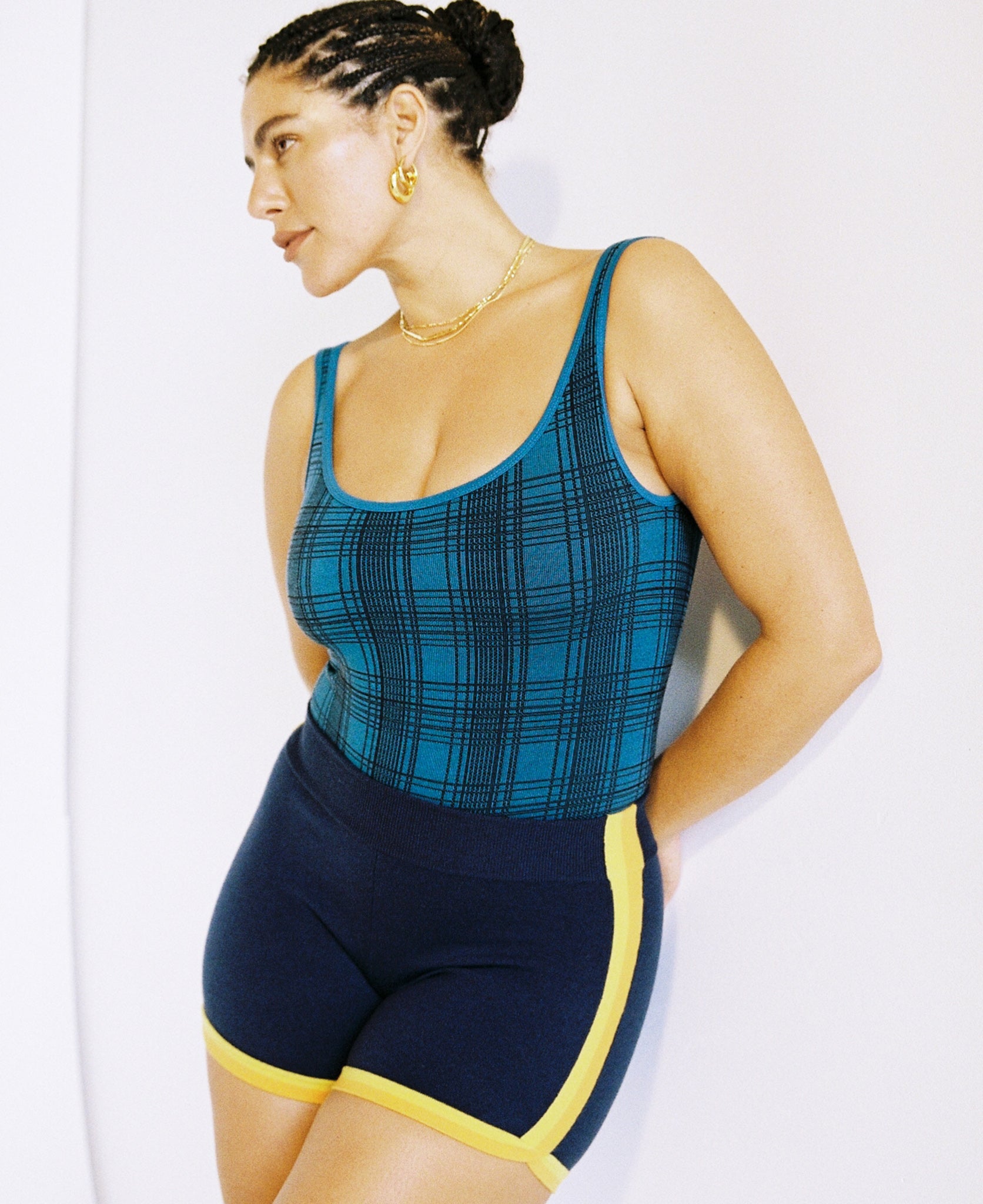 Female model wears the Nagnata Check-Back Bodysuit in teal & black