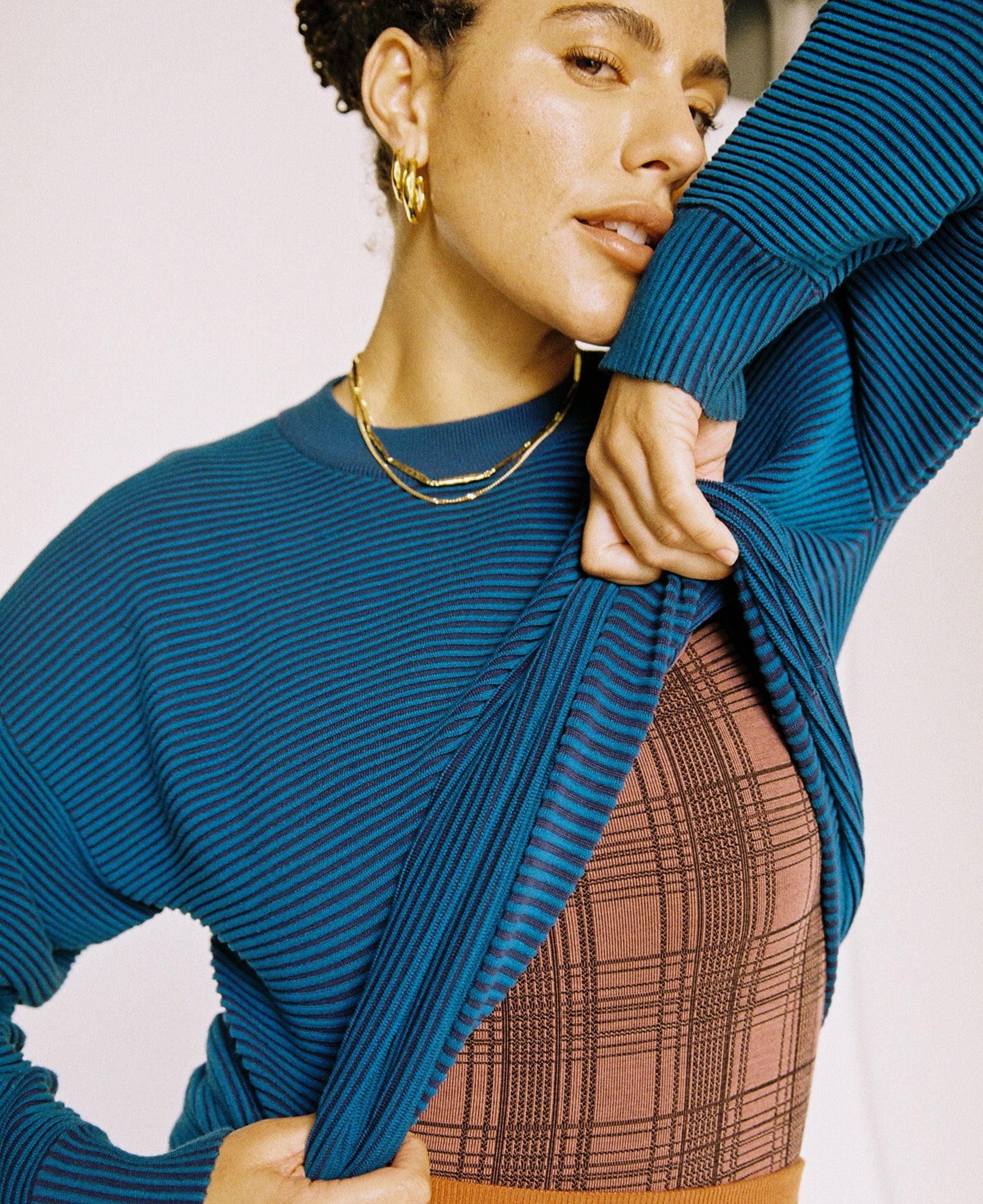 Female model wears the Nagnata Sonny Crew Neck Sweater in teal and navy