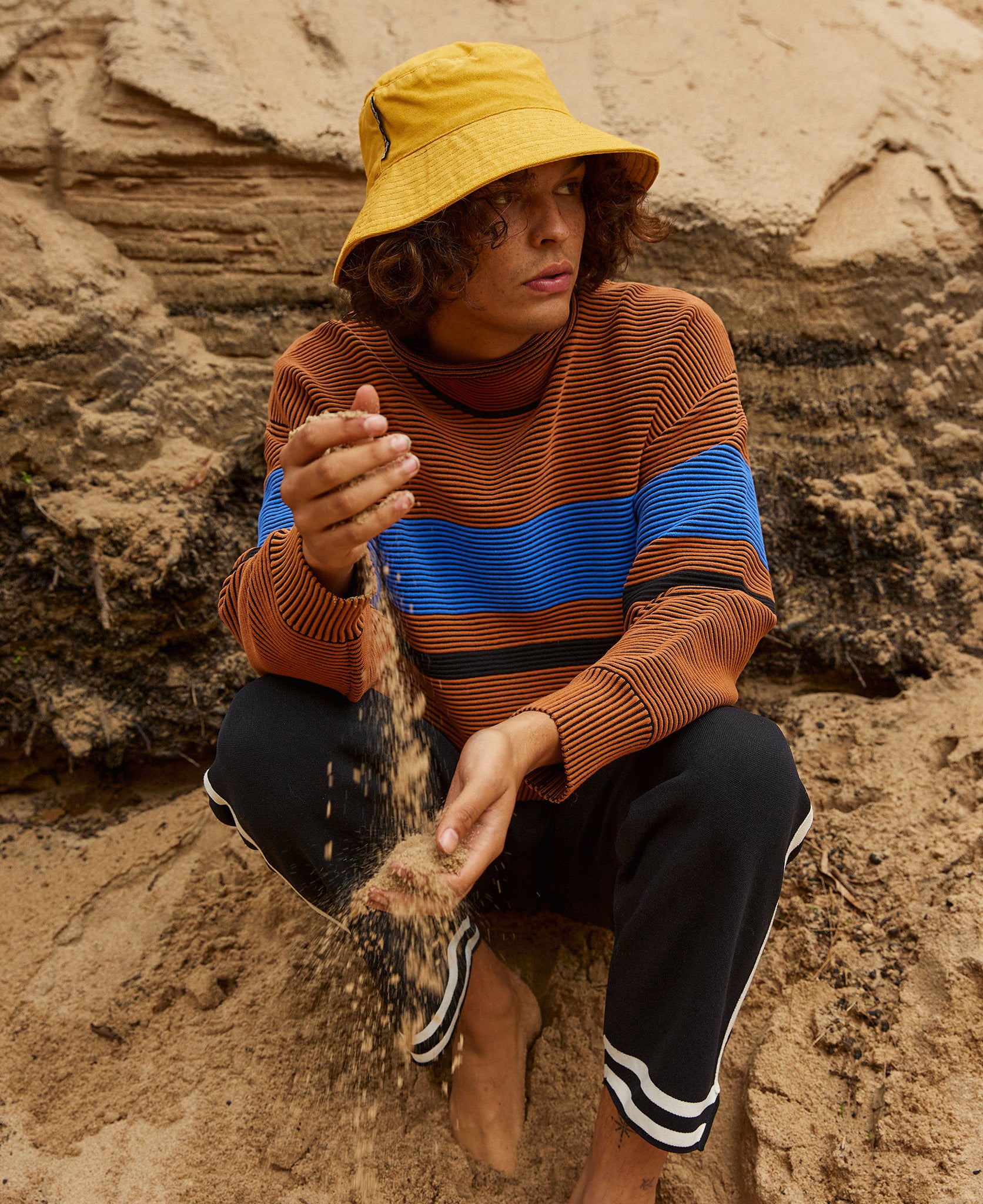 Female model wears the Nagnata Retro Rib Sweater in bronze and azure blue