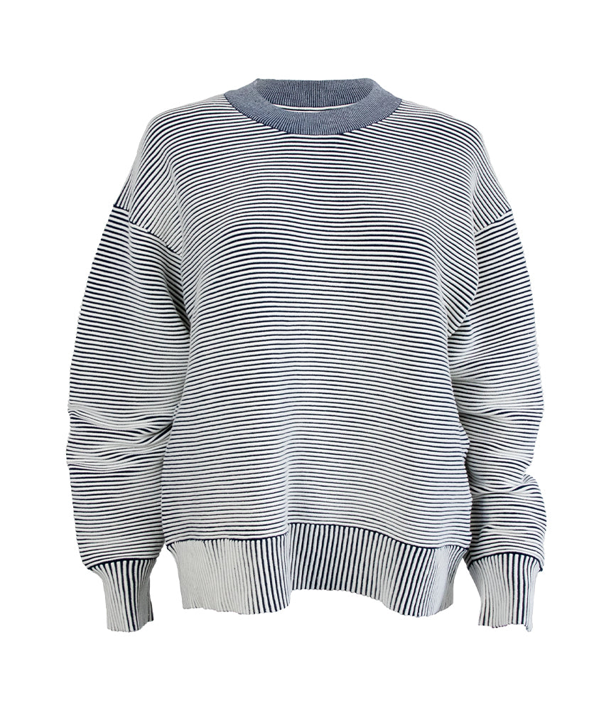 Male model wears the Nagnata Sonny Crew Neck Sweater in cream and navy