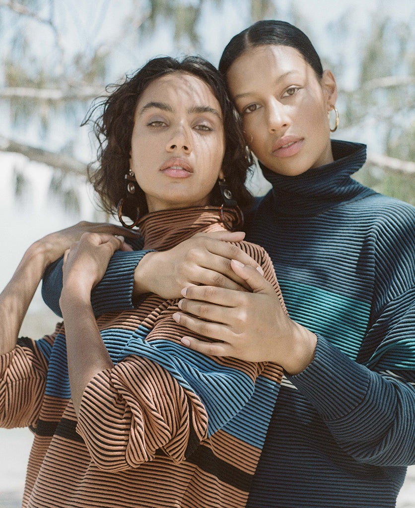 Female model wears the Nagnata Retro Rib Sweater in bronze and azure blue