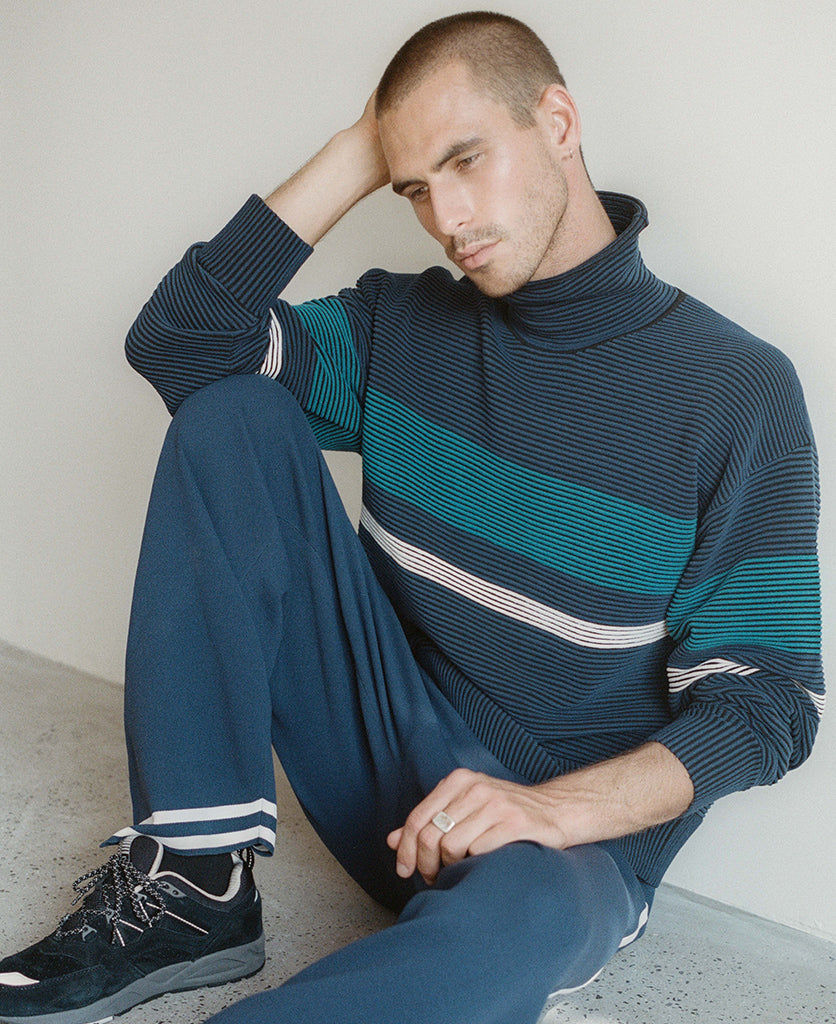 Female model wears the Nagnata Retro Rib Sweater in navy and teal blue