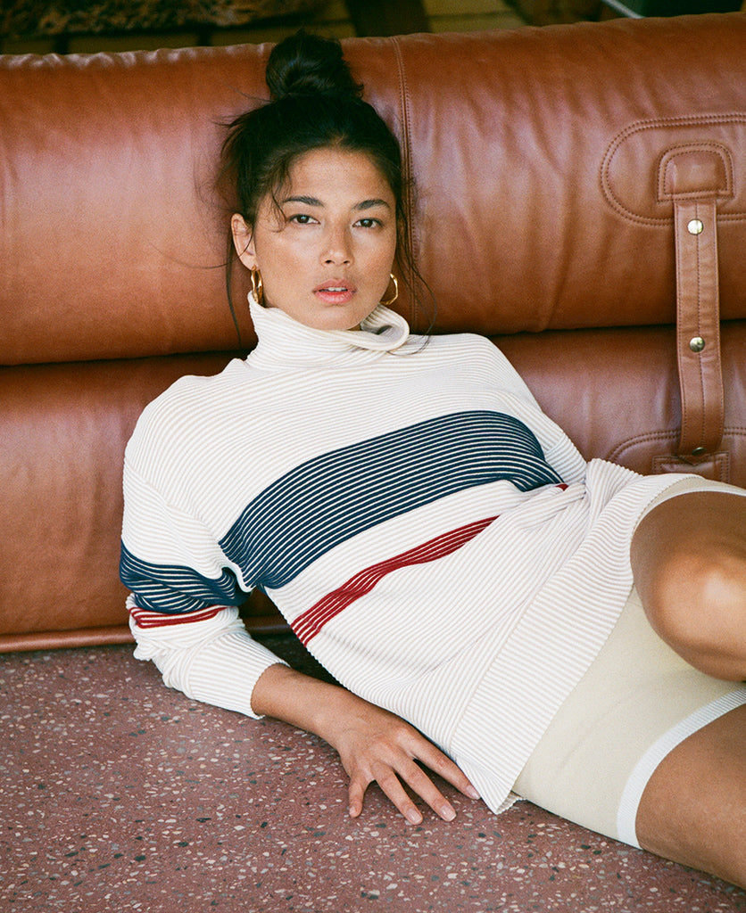 Female model wears the Nagnata Retro Rib Sweater in cream and navy