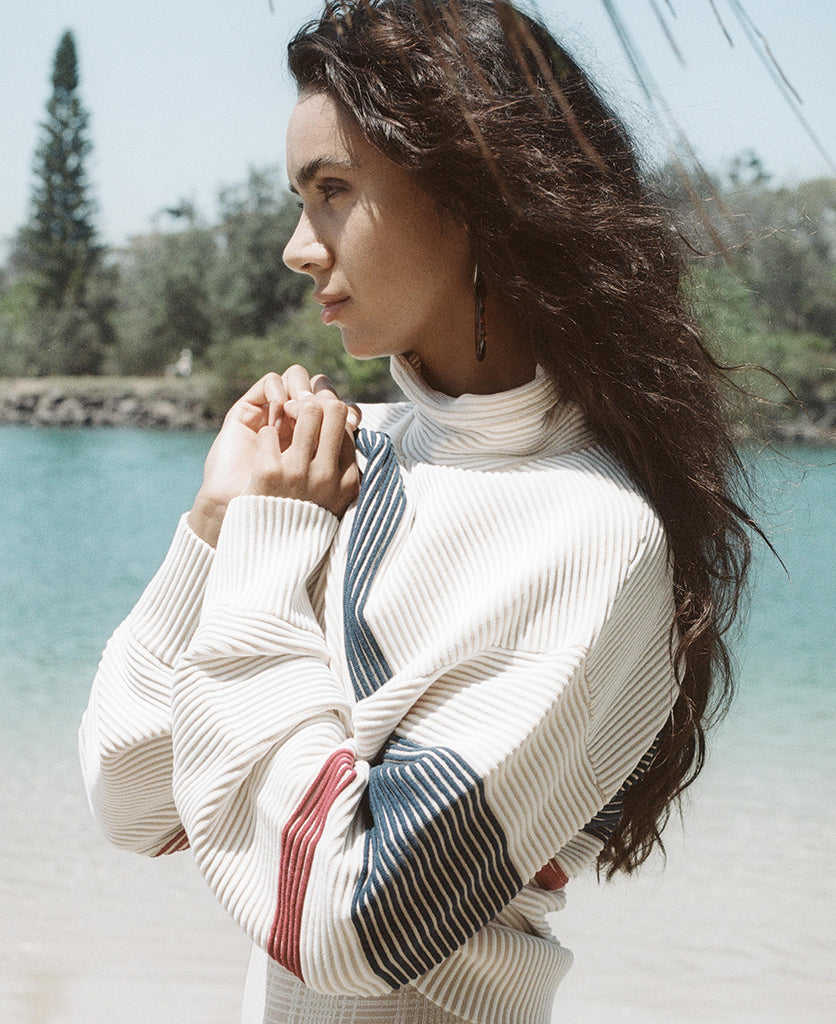 Female model wears the Nagnata Retro Rib Sweater in cream and navy