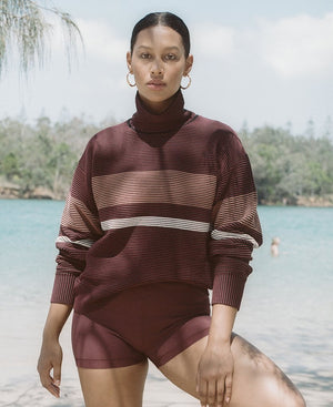 Female model wears the Nagnata Retro Rib Sweater in burgundy and blue, and the Yoni Short in lilac