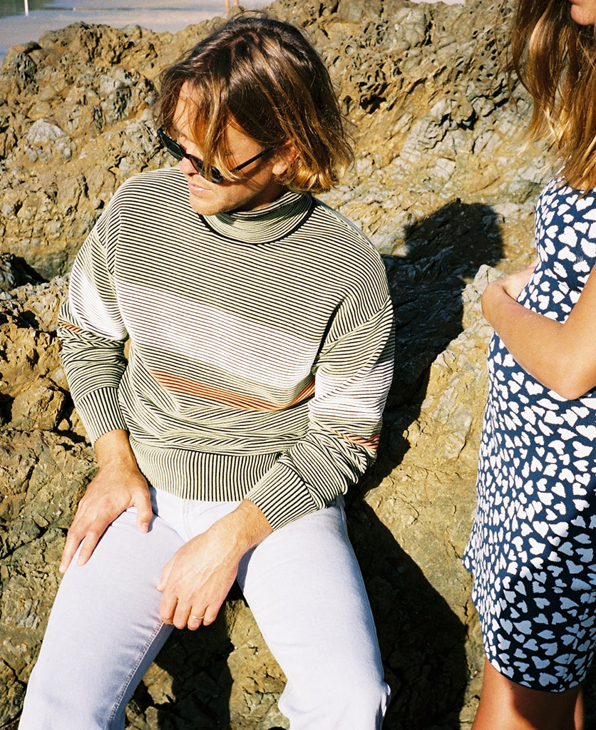 Female model wears the Nagnata Retro Rib Sweater in sage green and cream
